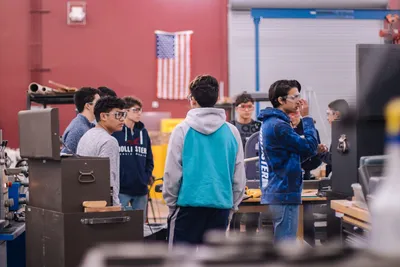 Teenagers working together in an educational workshop, promoting teamwork and learning.